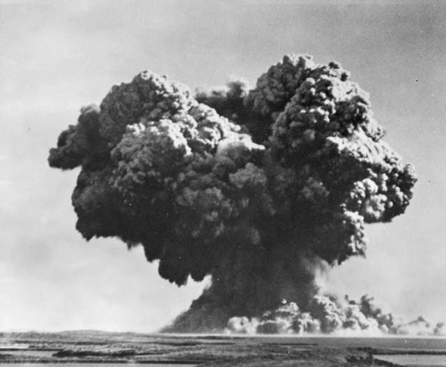 Black-and-white photograph of a huge column of water, smoke, and spray rising from the sea after an underwater atomic explosion