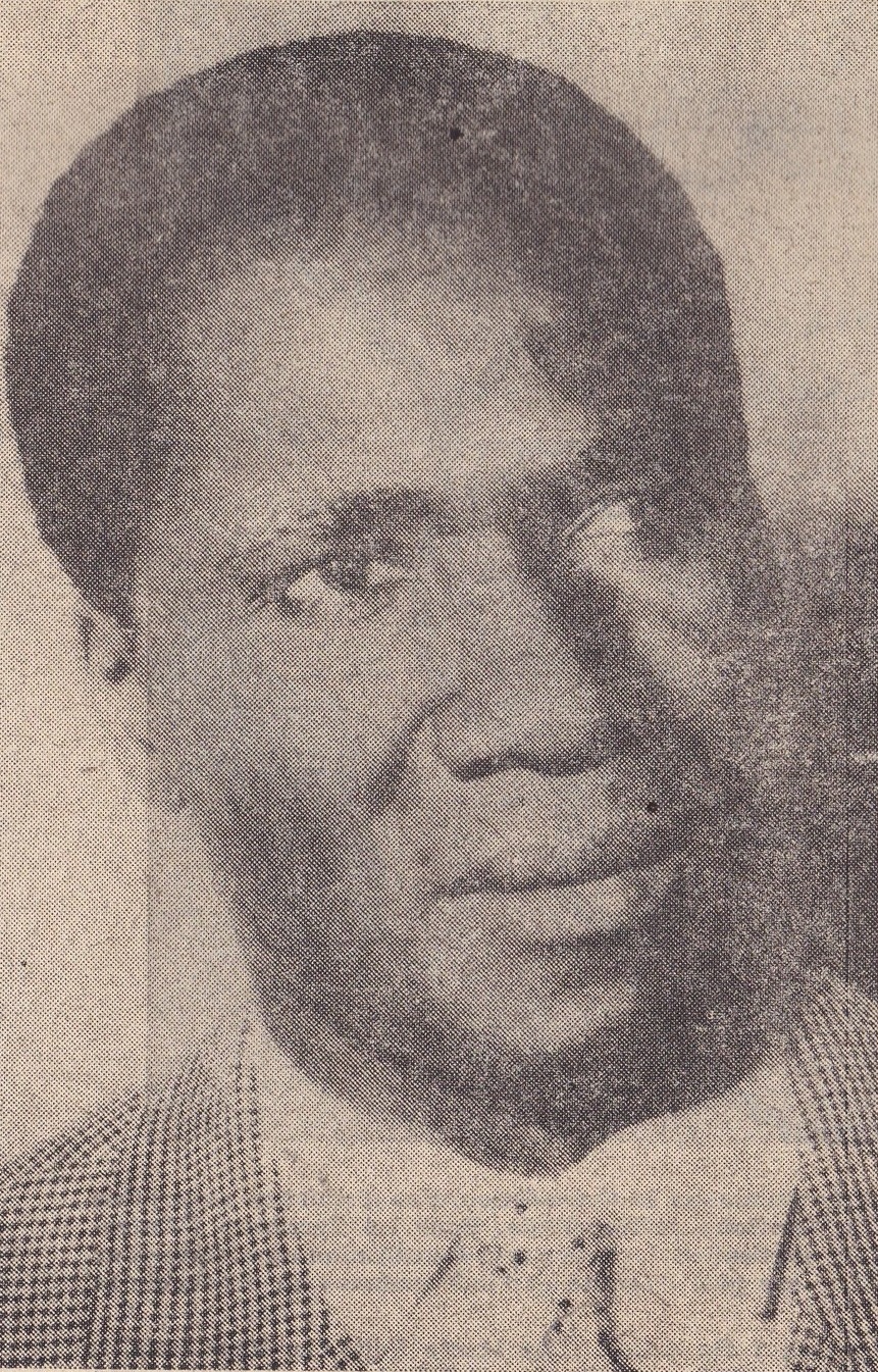 Grainy black and white newspaper portrait of Ahmed Sékou Touré, smiling slightly and wearing a checked jacket